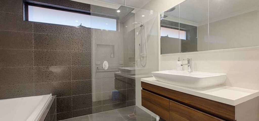 Stunning bathroom with glass petition, marble walls and modern vanity.