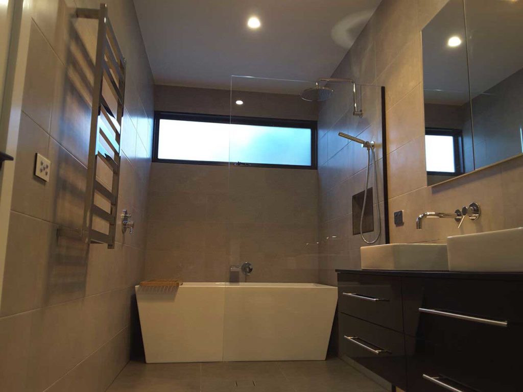 Glen Iris bathroom extension with glass partition, marbled tile and classic vanity.