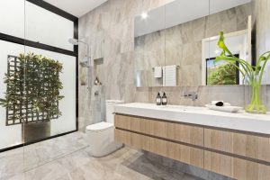 Elegant marble bathroom with modern shower and plants.